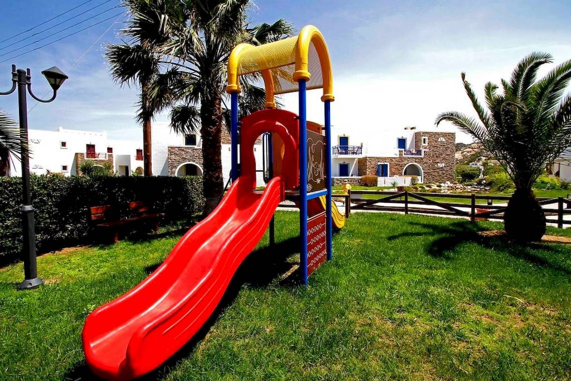 Roter Rutsch im Plaza Beach Hotel mit grünem Rasen und Palmen im Hintergrund.