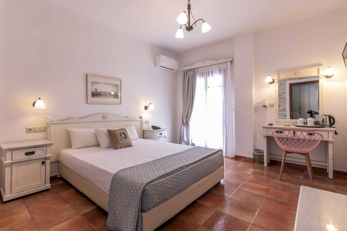 Schlafzimmer im Plaza Beach Hotel mit Bett, Nachttischen und Klimaanlage