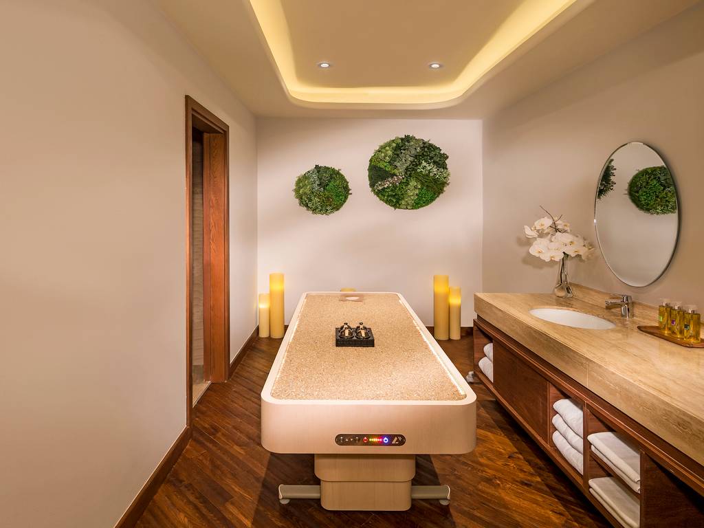 Behandlungsraum im Retreat Palm Dubai MGallery by Sofitel mit Massageliege und Aromalampen.