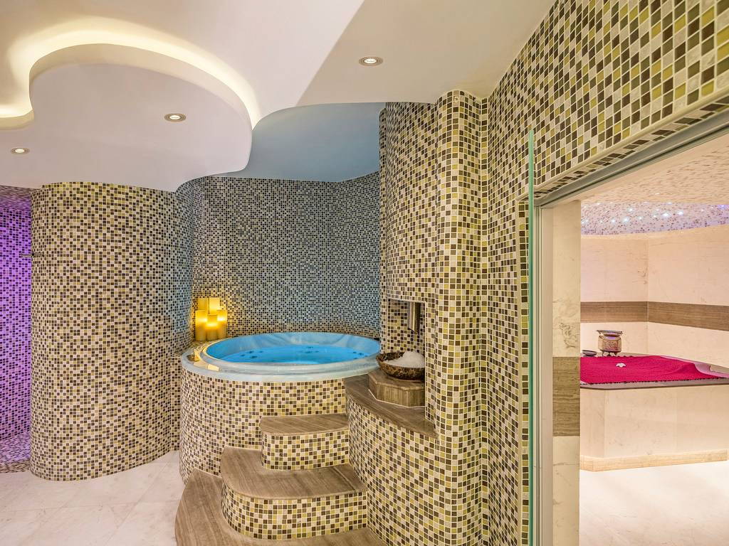 Jacuzzi-Raum im The Retreat Palm Dubai MGallery by Sofitel mit gefliesten Wänden und marmorner Treppe.