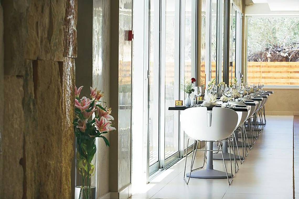 Innenbereich des Napa Mermaid Hotel & Suites mit einer Reihe von Tischen und Stühlen.
