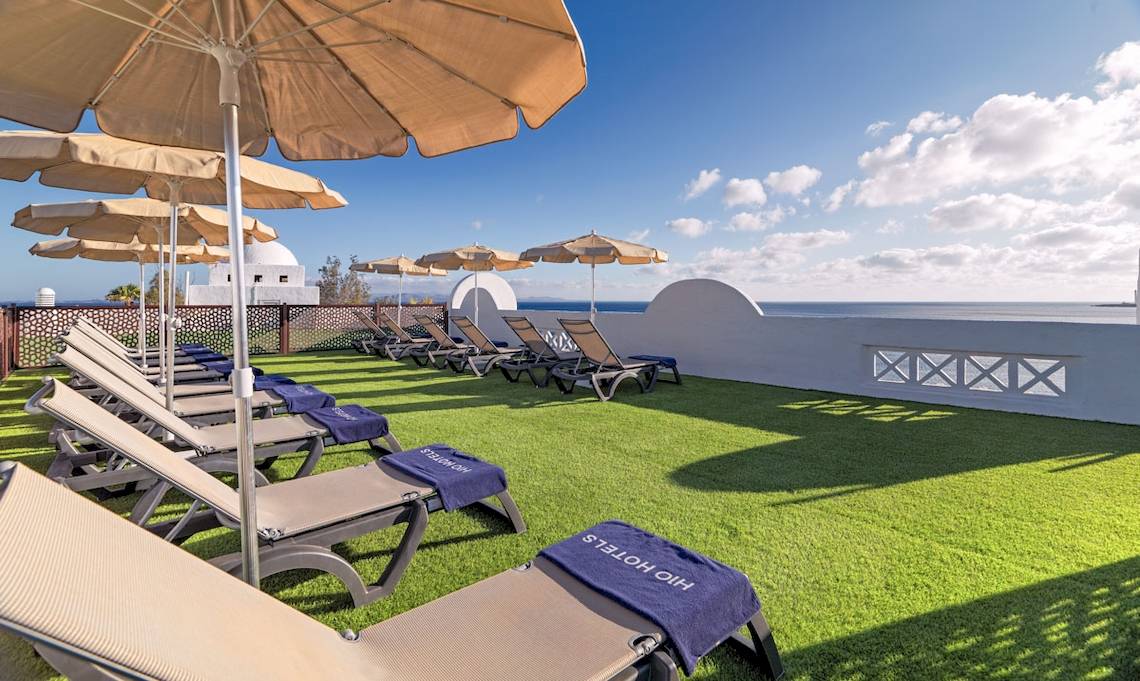 Dachterrasse des H10 Timanfaya Palace mit Sonnenliegen, Überdachungen und Meerblick