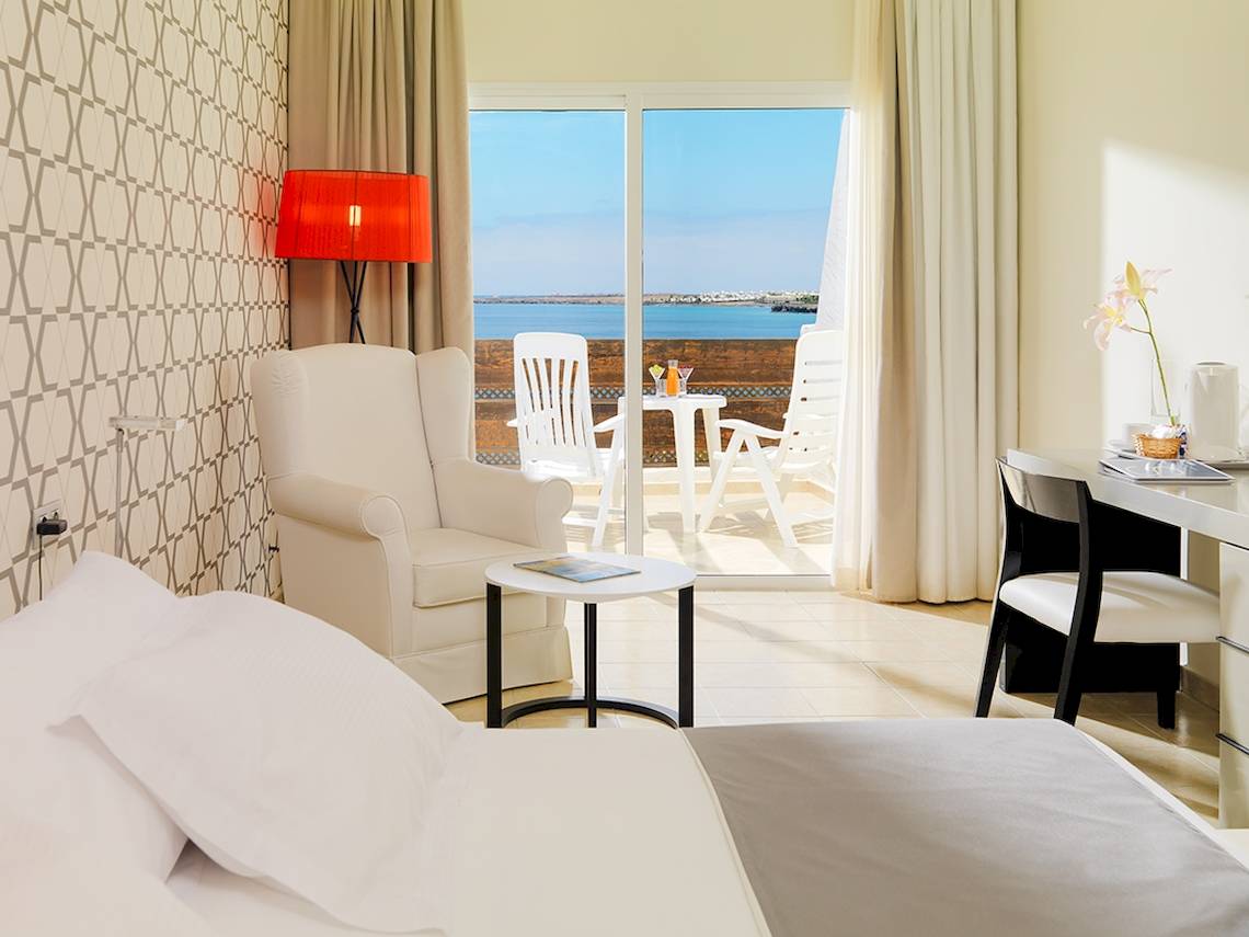 Zimmer im H10 Timanfaya Palace mit Balkon und Meerblick, inklusive Möbeln und Dekoration.