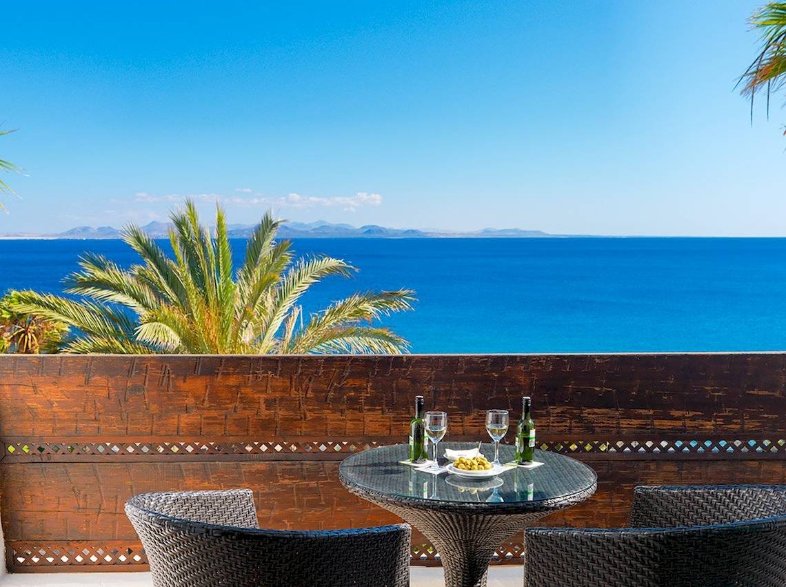 Balkon im H10 Timanfaya Palace mit Blick auf das Meer und Palmen