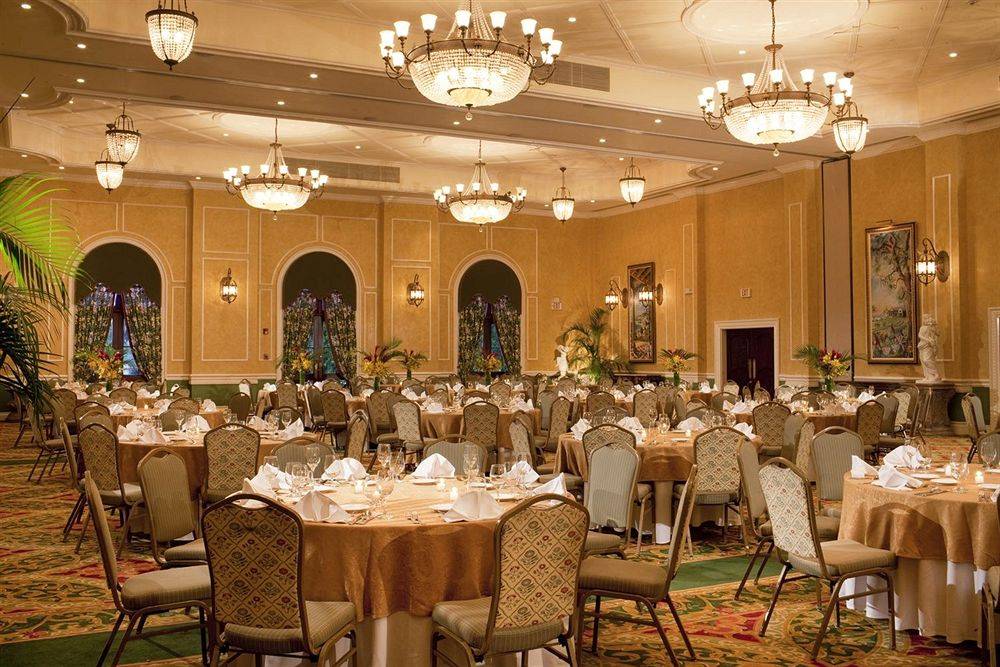 Bankettsaal im Sandals Whitehouse European Village & Spa mit vielen gedeckten Tischen und kristallen Kronleuchtern.