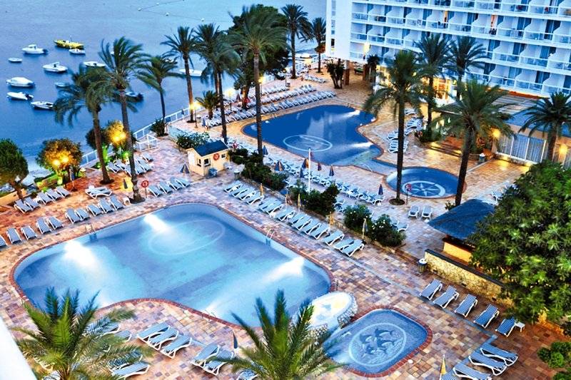 Luftaufnahme des Poolbereichs des Ibiza Twins Hotels mit mehreren Swimmingpools, Liegestühlen und Palmen