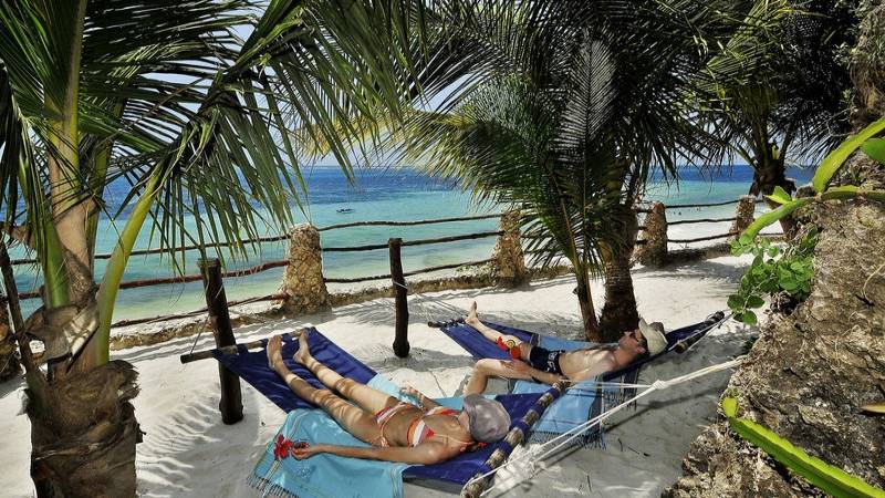 Zwei Personen entspannen auf Hängematten am Strand des Bahari Beach Hotels