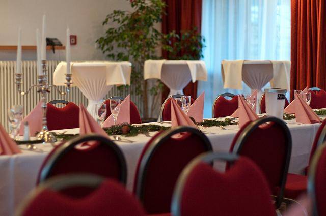 Bankettsaal im Leonardo Hotel Hamburg Elbbrücken mit festlich gedeckten Tischen.