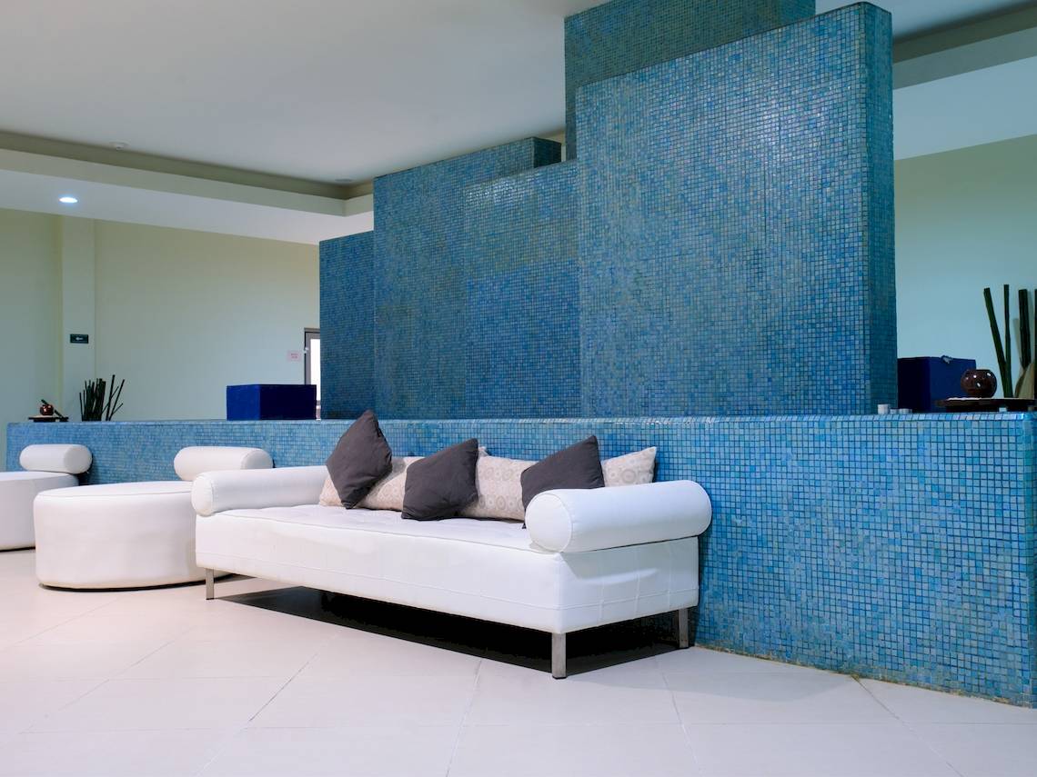 Lobby des Grand Sunset Princess All Suites Resorts mit blauen Fliesen und weißen Möbeln.