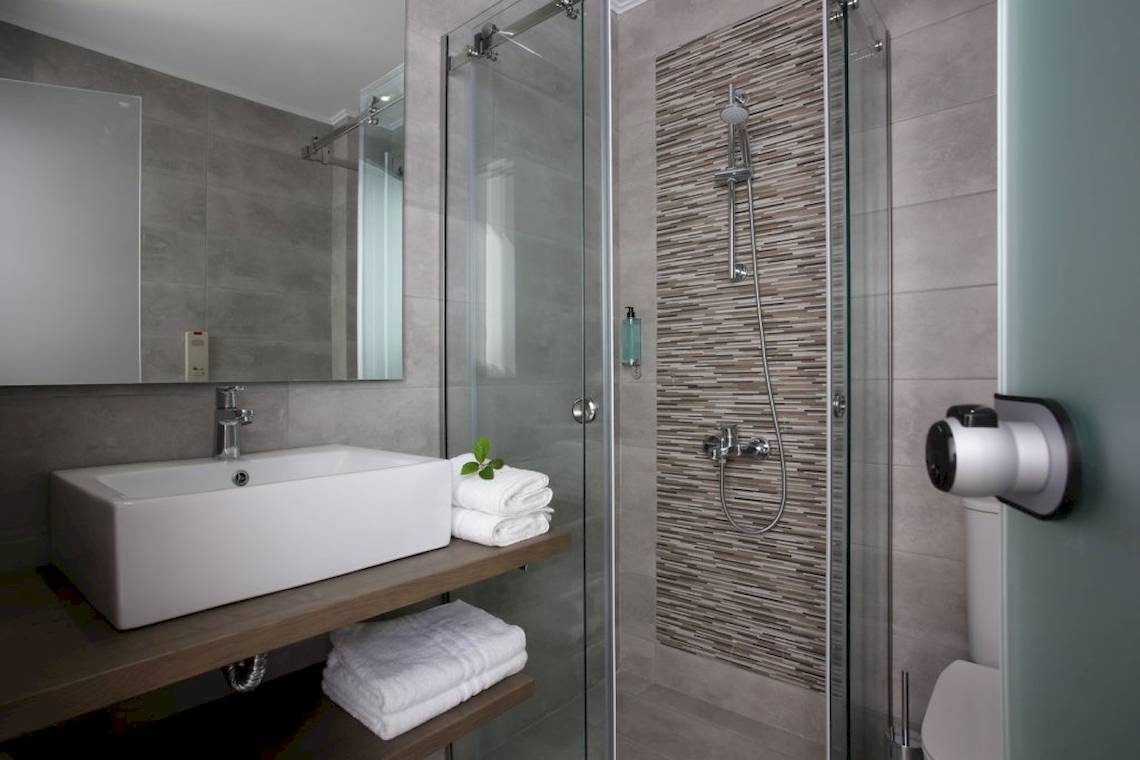 Badezimmer im Paradise Hotel Corfu mit eckigen Fliesen und einer Dusche.