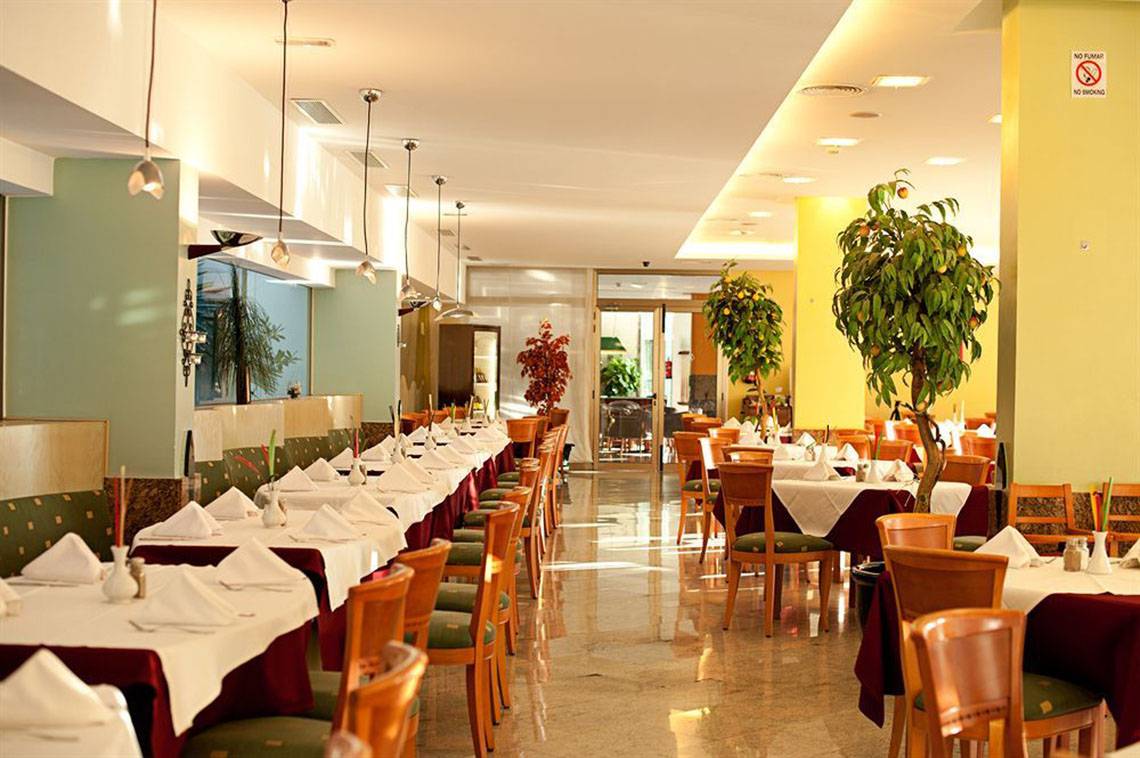Restaurant des LIVVO Costa Taurito Hotels mit gedeckten Tischen und Stühlen.