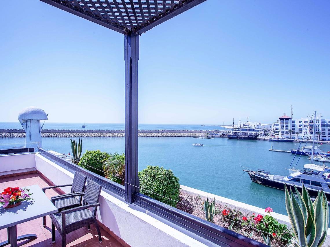 Terrasse mit Meerblick im Bianca Beach Resort mit Tischen, Stühlen und Blumen