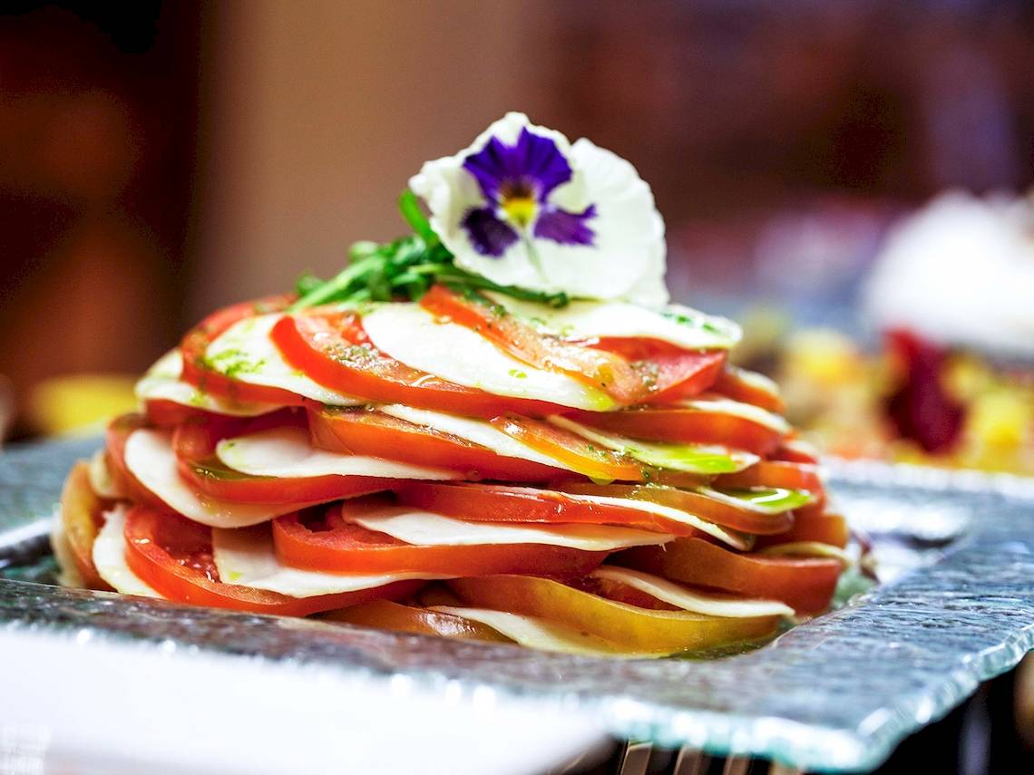 Eine Schicht von Tomaten und Mozzarella mit einer Blume garniert im Bianca Beach Resort.
