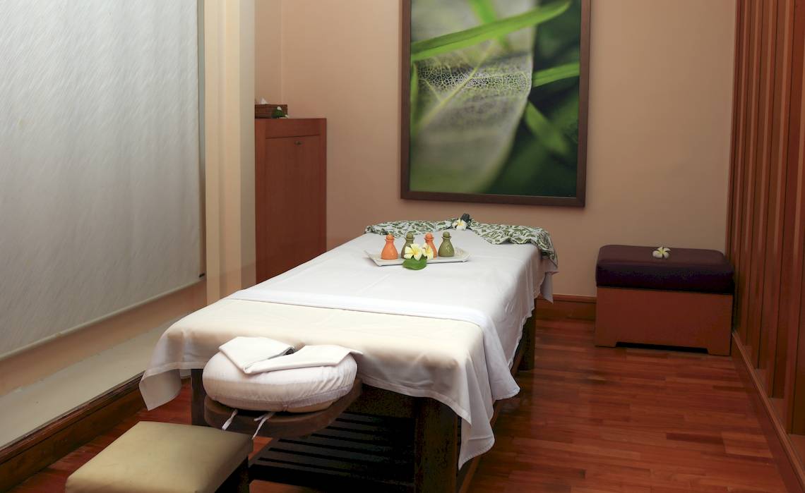 Massage-Behandlungsraum im Wyndham Garden Salalah Mirbat mit einem Bett, Kissen und einer weißen Decke.