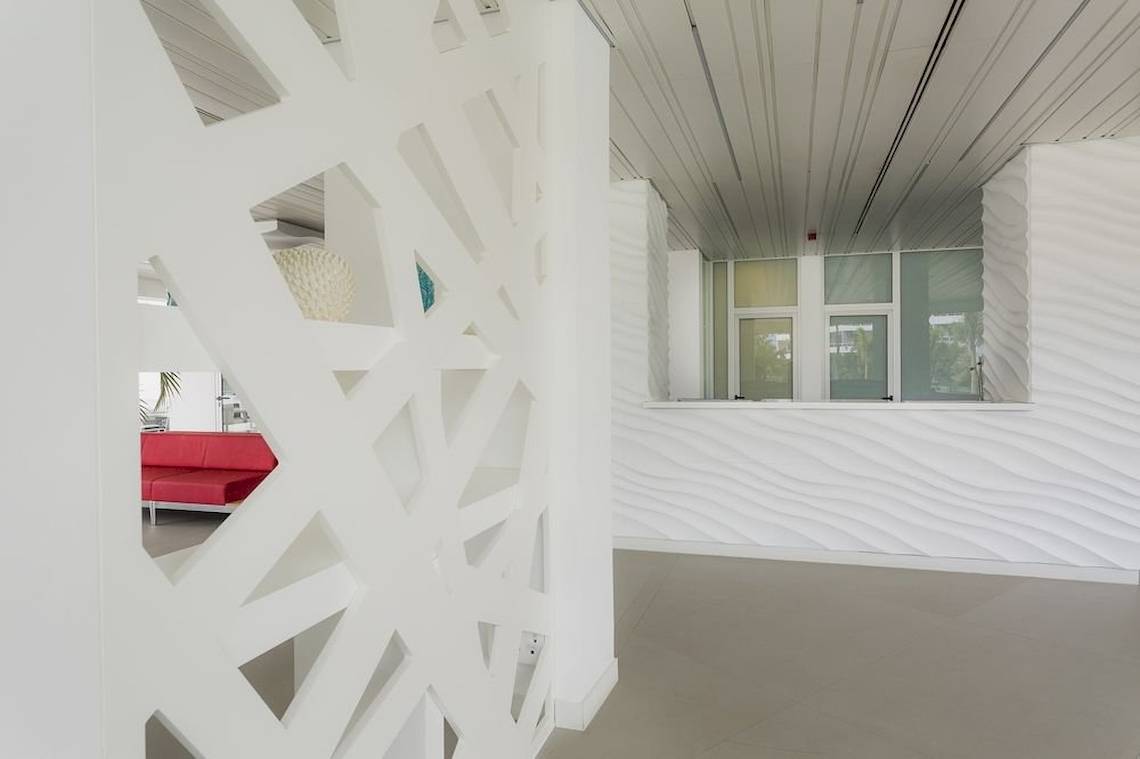 Inneneinrichtung des Caserio Hotels mit weißen gewellten Wänden und einem roten Sofa.