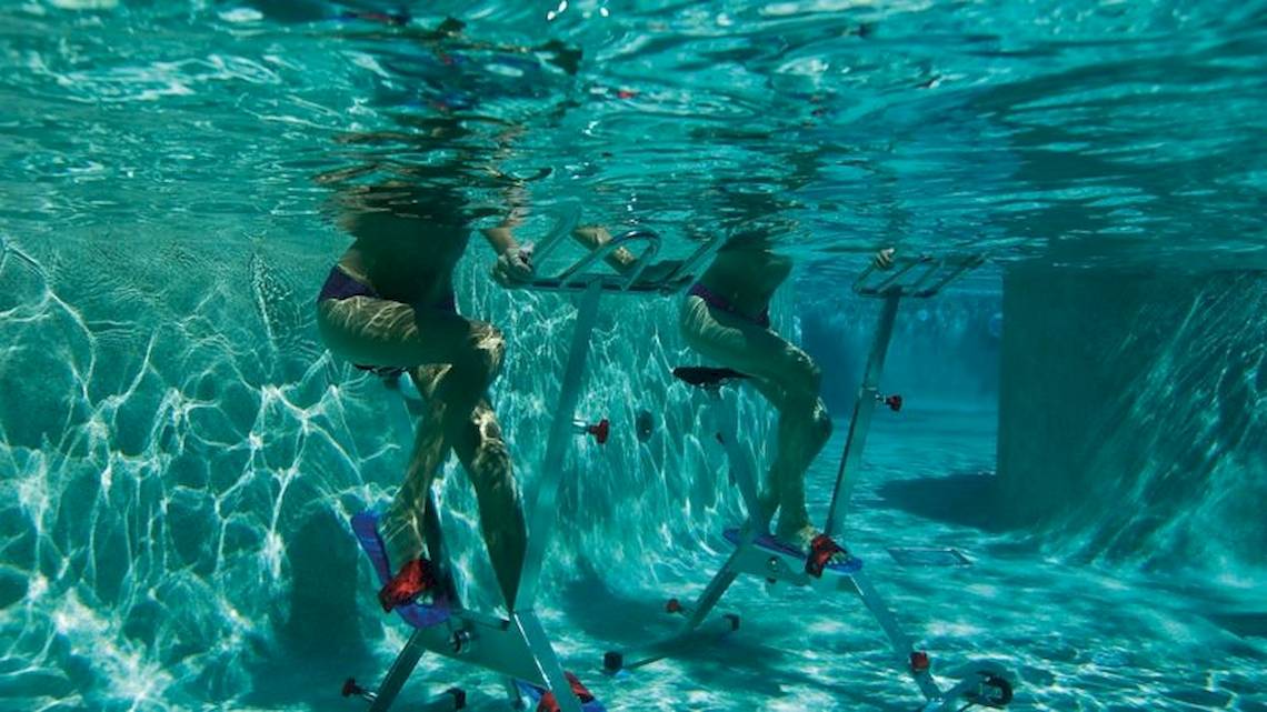 Zwei Personen schwimmen mit Schwimmtrainer im Pool des Secrets Akumal Riviera Maya