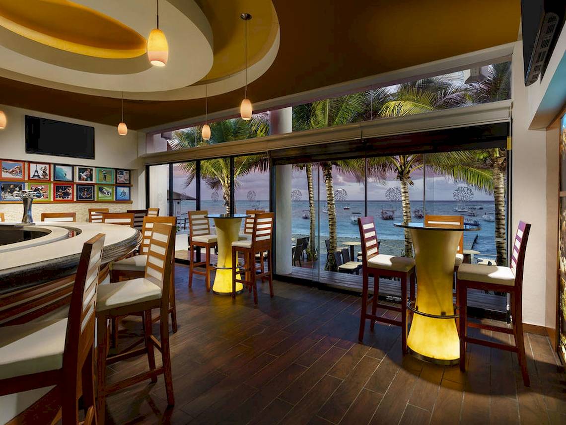 Innenansicht der Bar im The Reef Coco Beach Hotel mit Blick auf das Meer
