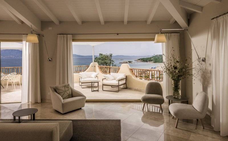 Wohnbereich im Cala Cuncheddi Hotel mit Blick auf das Meer und die Berge.