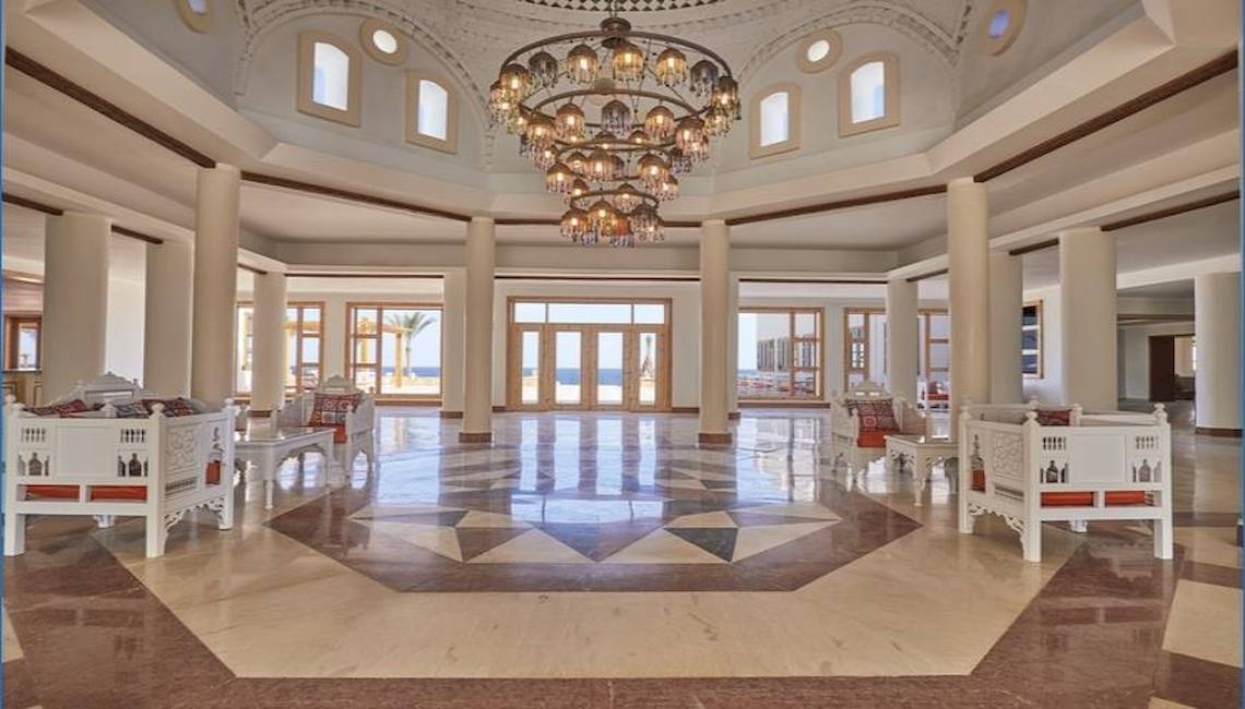 Lobby des JAZ Neo Reef Marsa Almaz Hotel mit weißen Möbeln und einem großen Kronleuchter