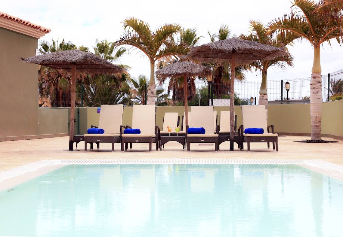 Reihe von Lounge-Stuhlen am Pool im BLUESEA Aloe Corralejo Hotel