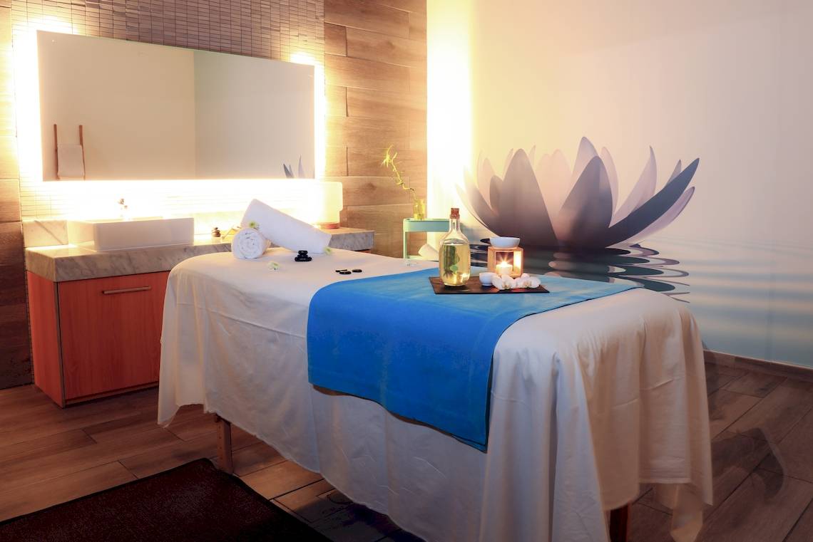 Massagebereich im Bluesea Aloe Corralejo Hotel mit blauer Tischdecke und Lotus-Wandbild.