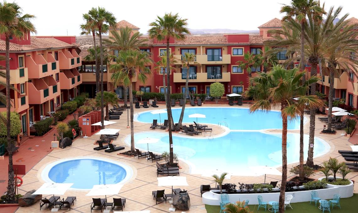 Luftaufnahme des Bluesea Aloe Corralejo Resorts mit Swimmingpools und Sonnenliegen.