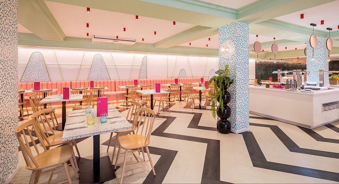 Innenansicht des Restaurants im Aparthotel Allegro Isora mit gemusterten Wänden und Möbeln.