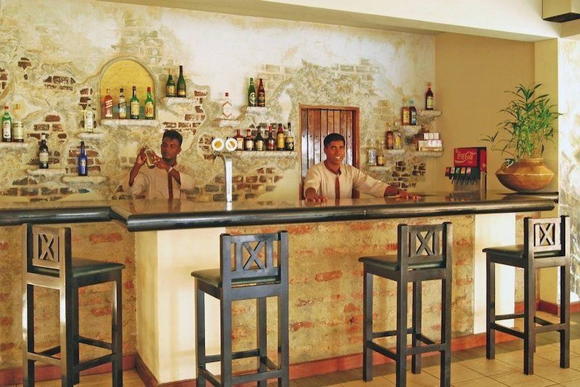 Bar im Mermaid Hotel & Club mit zwei Barkeepern und Getränken
