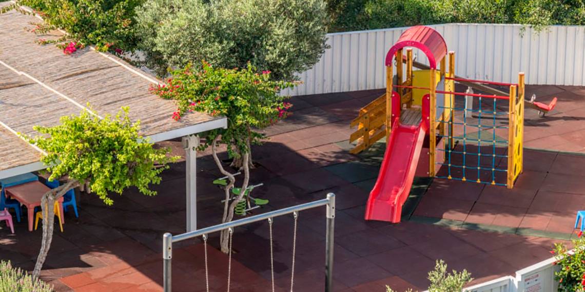 Kinderspielplatz im Nissi Beach Resort mit Rutsche, Schaukel und Klettergerüst.