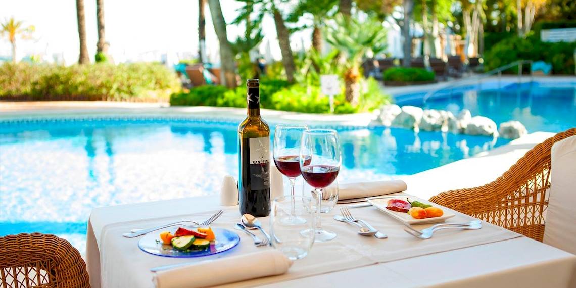 VIVA Golf Adults Only Hotel mit Tisch am Pool mit Essen und Wein