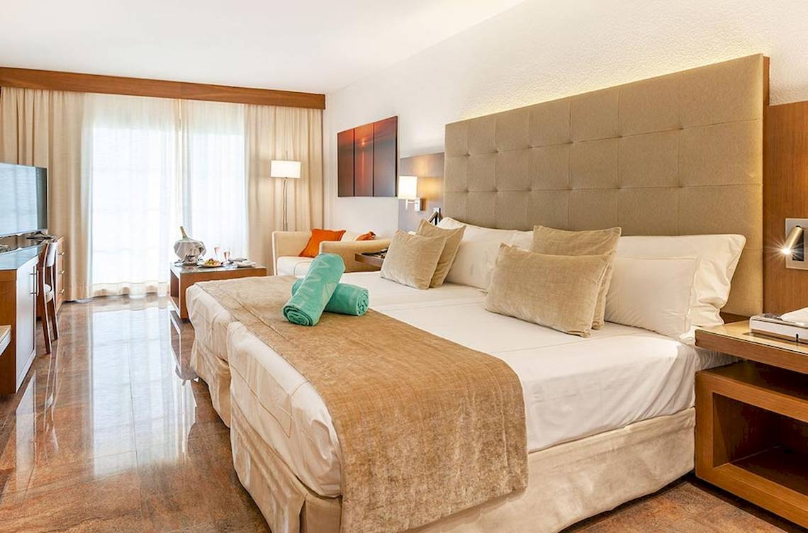 Hotelzimmer im VIVA Golf Adults Only Hotel mit Doppelbett, Dekor und Fenstern.