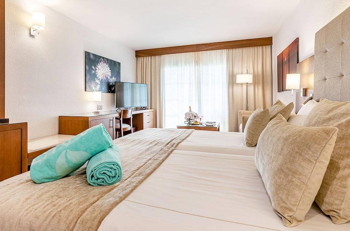 Doppelbettzimmer im Viva Golf Adults Only Hotel mit Fernseher und Schreibtisch.