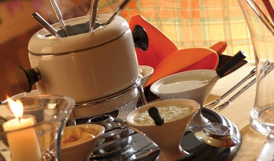 Fonduetisch im Charmillion Club Resort mit Käse, Früchten und Kerzen.