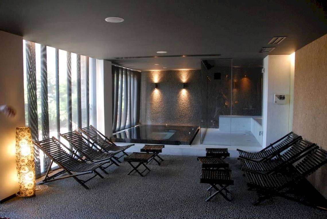 Innenbereich des Doryssa Seaside Resort mit Lounge-Stuhlreihen und Whirlpool.