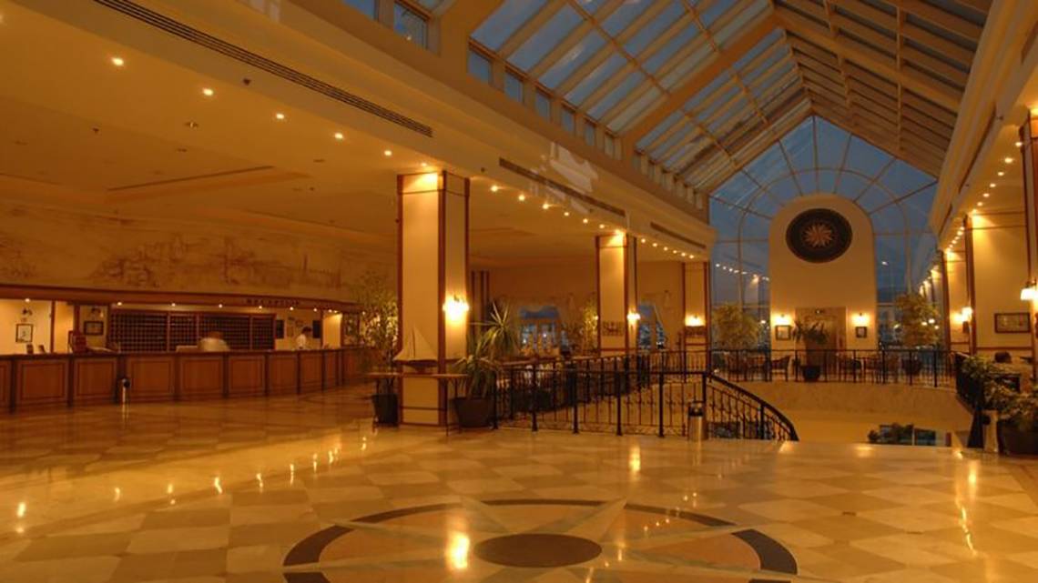 Die Lobby des Selectum Colours Bodrum Hotels mit einer Glaskuppel, illuminierten Säulen, und einer zentrierten Stern-Design auf dem Boden.