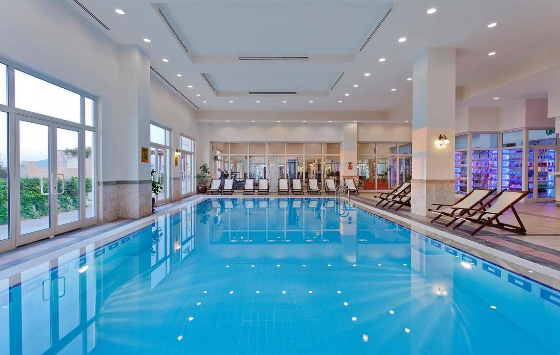 Innenpool des Selectum Colours Bodrum Hotels mit Liegestühlen und Glaswänden
