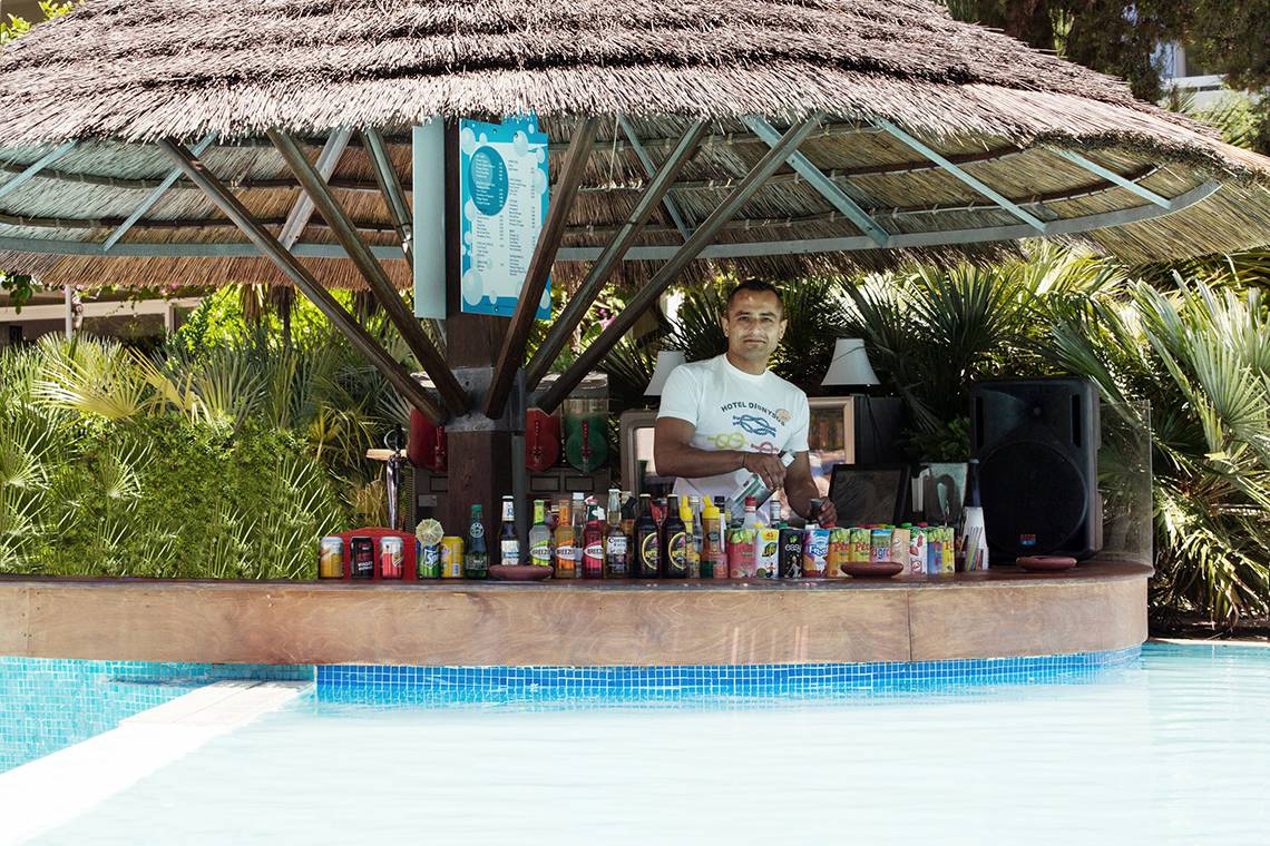Ein Barkeeper steht an der Poolbar des Dionysos Hotels.
