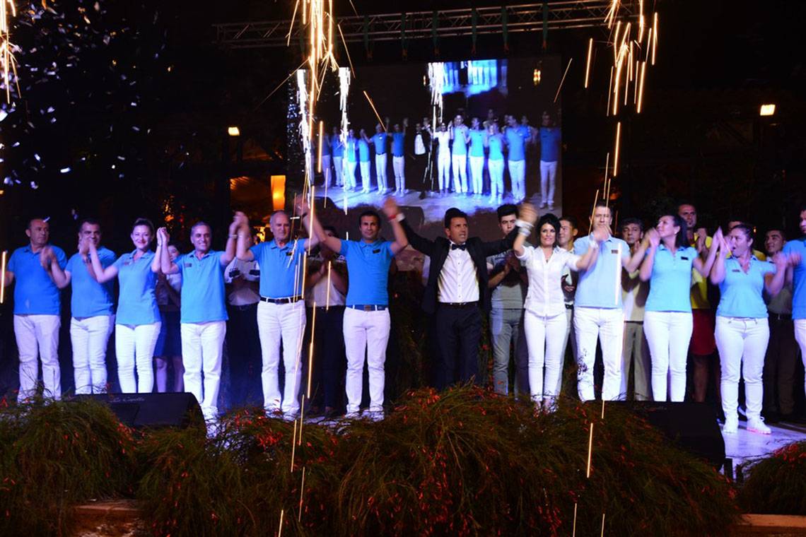Gruppe von Leuten auf der Bühne im Marti Myra Hotel mit Feuerwerk und Applaus.