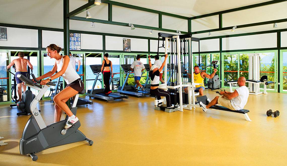 Fitnessstudio im Hotel Marti Myra mit mehreren Personen, die auf verschiedenen Geräten trainieren.