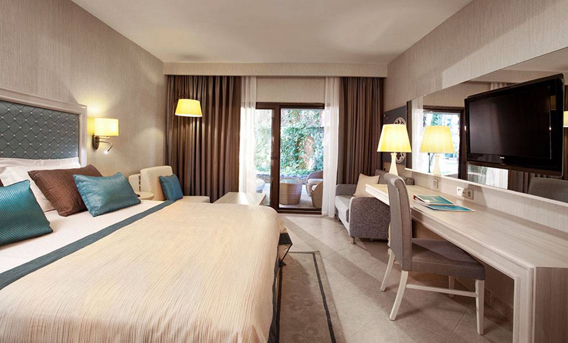 Hotelzimmer im Marti Myra mit großem Bett, Schreibtisch, Fernseher und offener Terrasse.