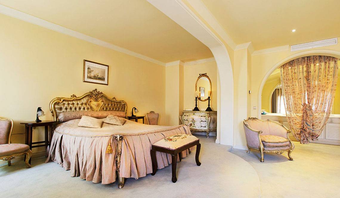 Luxuriöses Schlafzimmer im Marti Myra Hotel mit einem großen Bett, goldenen Akzenten und einer eleganten Einrichtung.