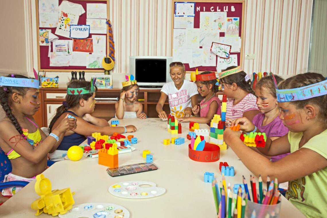 Kinder basteln im Titan Select Hotel mit bunten Farben und Spielzeug.