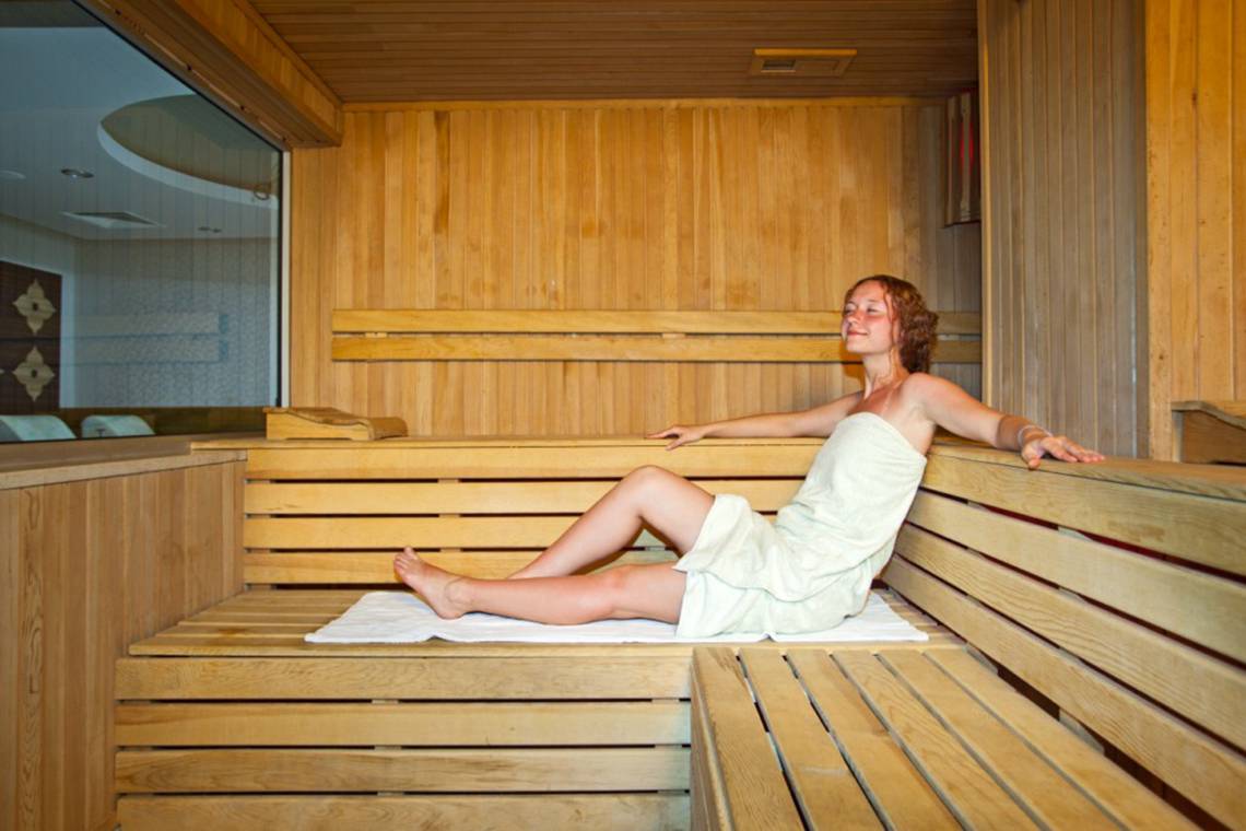 Frau in einer Holzsauna im Titan Select Hotel
