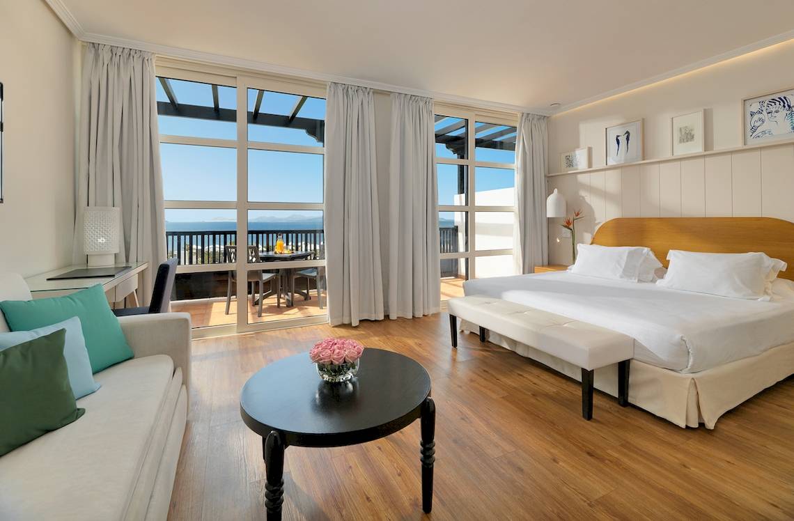 Schlafzimmer im H10 Rubicon Palace Hotel mit Blick auf den Balkon.