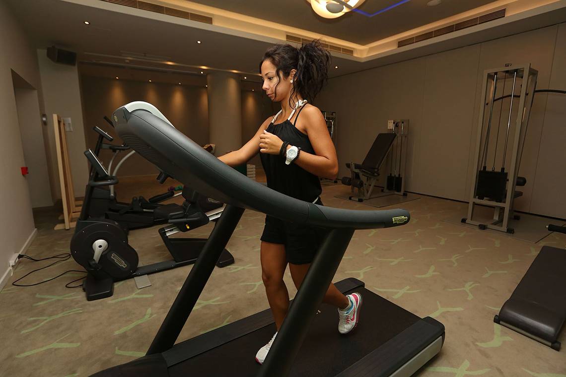Frau im Minos Mare Royal Hotel Fitnesscenter auf einem Laufband