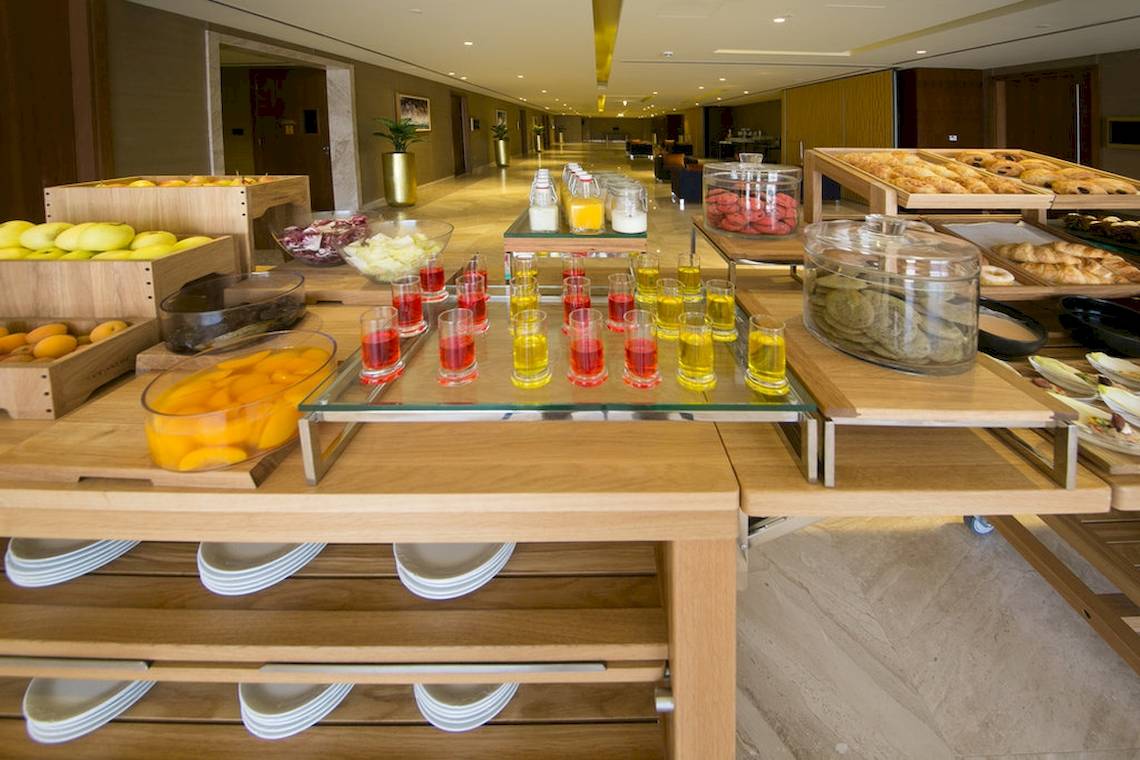 Frühstücksbuffet im Grand Millennium Muscat mit Obst, Getränken und Gebäck.