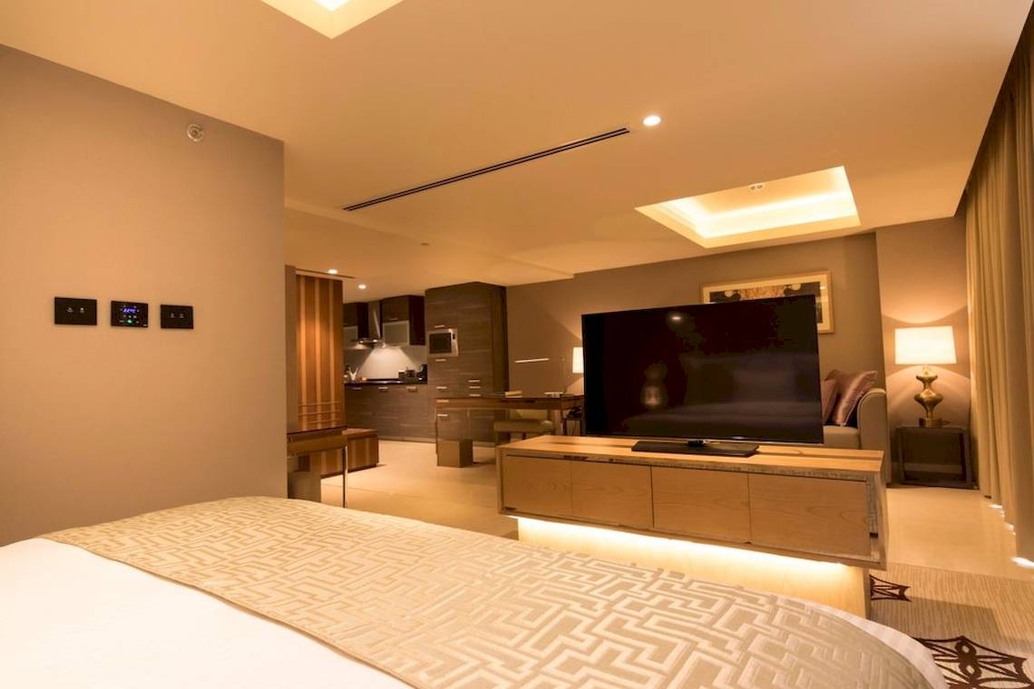 Suite Zimmer im Grand Millennium Muscat mit Fernseher und Wohnbereich