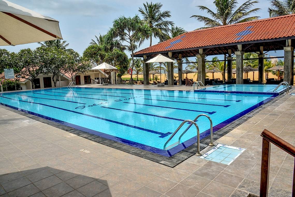 Außenpool des Goldi Sands Hotels mit Sonnenschirmen und Pavillon.