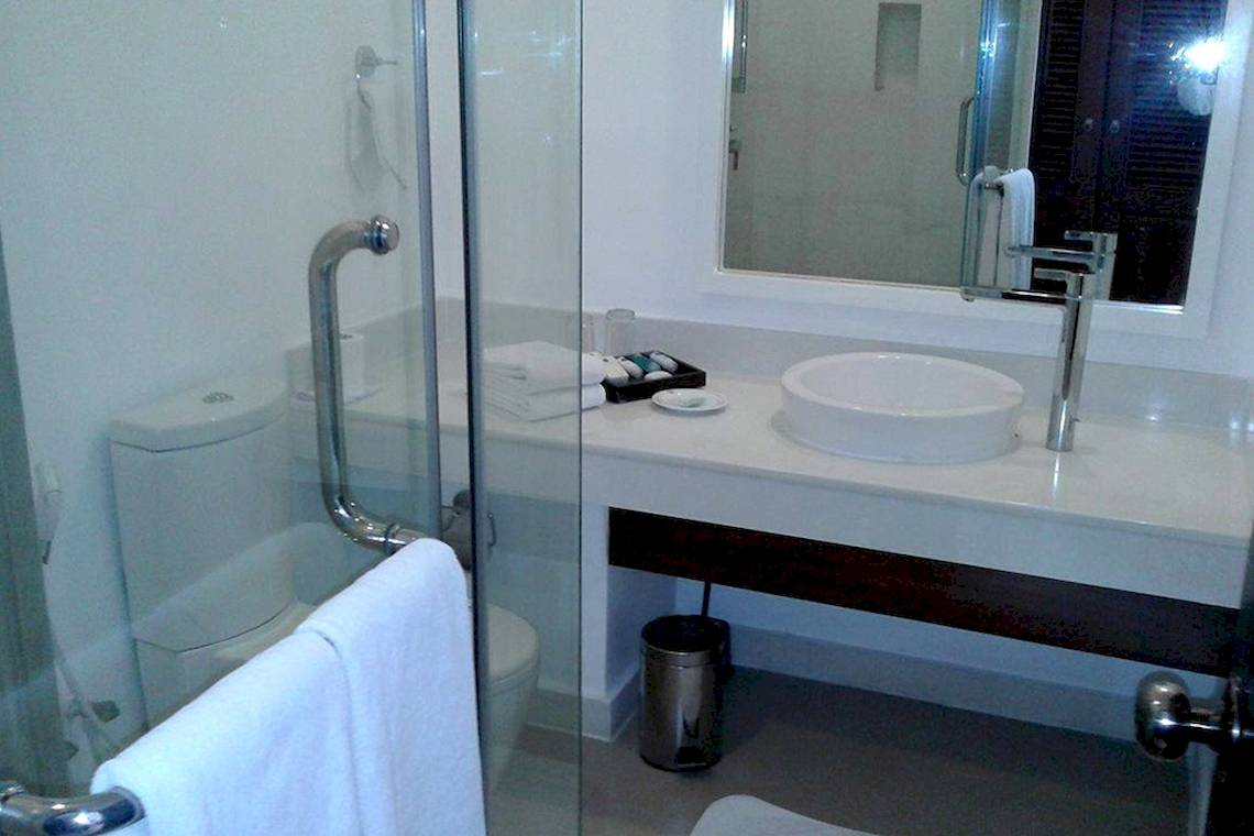 Goldi Sands Hotel Badezimmer mit Glasdusche, Waschbecken und Toilette.