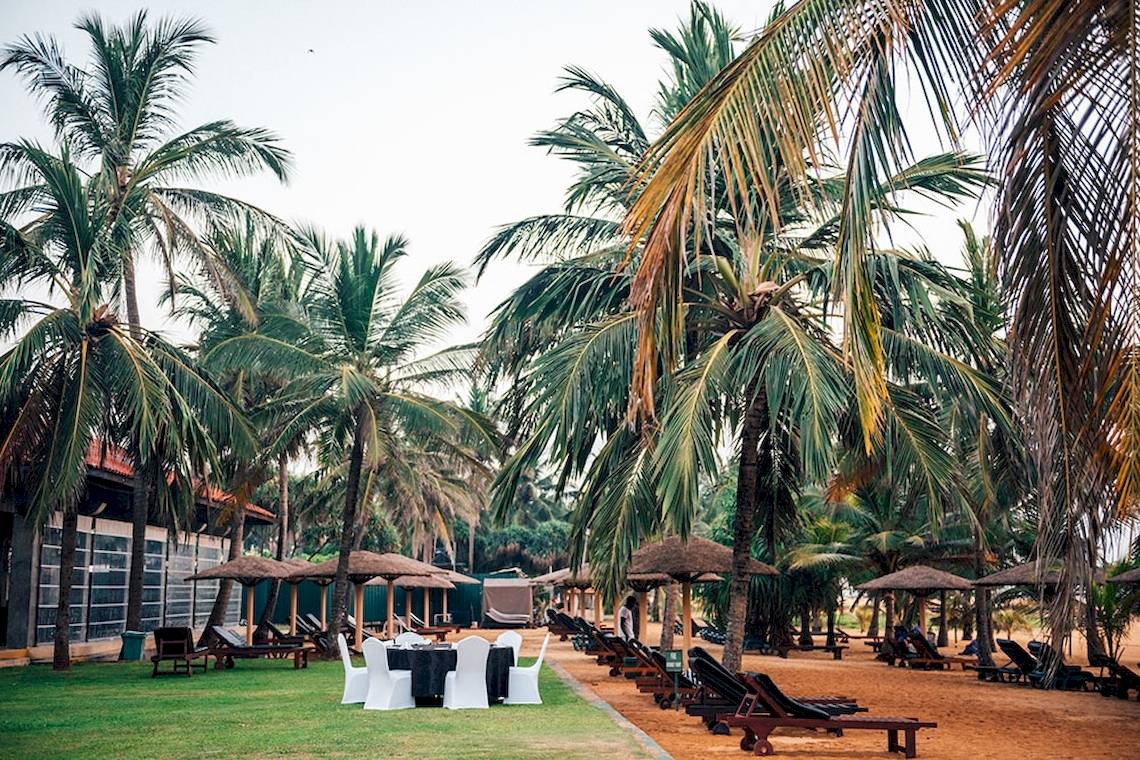 Außenbereich des Goldi Sands Hotels mit Lounge-Sesseln unter Palmen